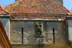 Rothenburg ob der Tauber, Maske über dem Burgtor, aus der im Mittelalter heißes Pech floss